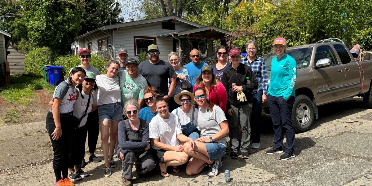 Volunteers smiling in front of house