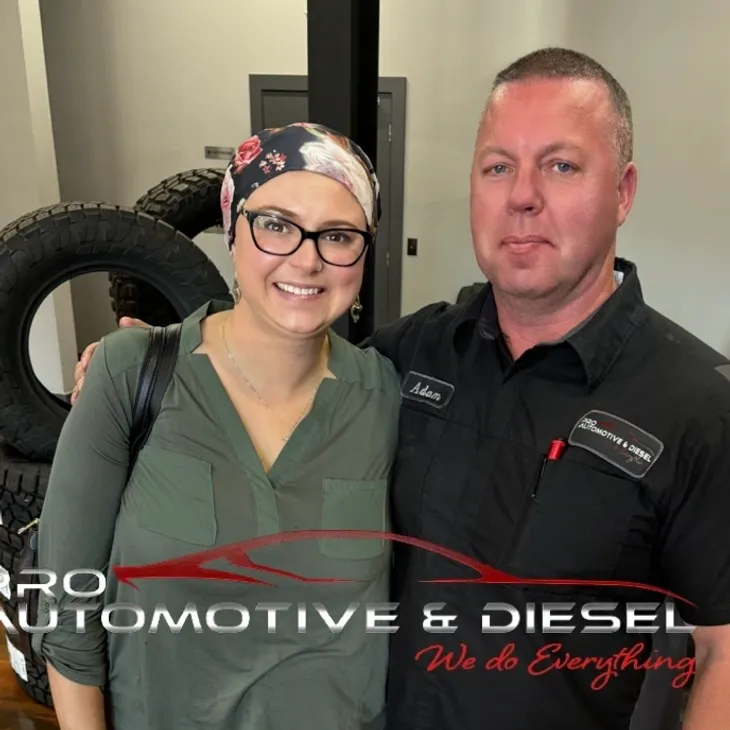 Man and woman smiling at auto shop