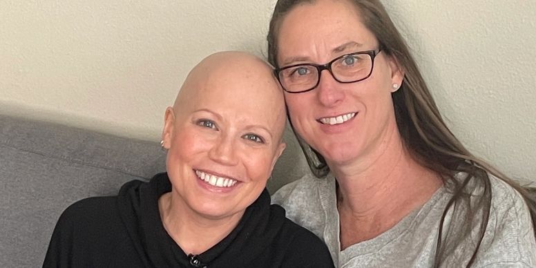 Two women smiling on a couch