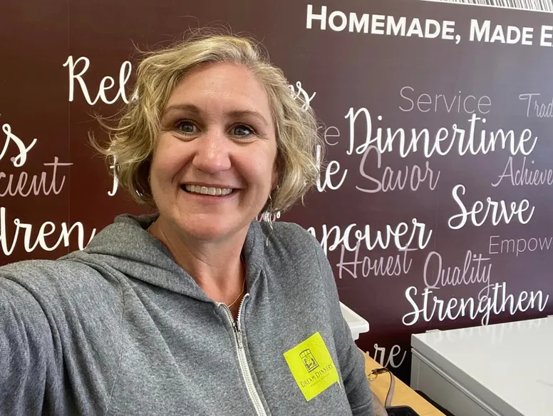 Happy woman with curly hair, word wall backdrop