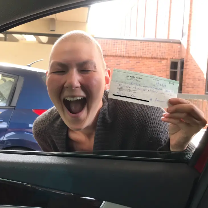 Excited person holding a ticket or pass near a car window.