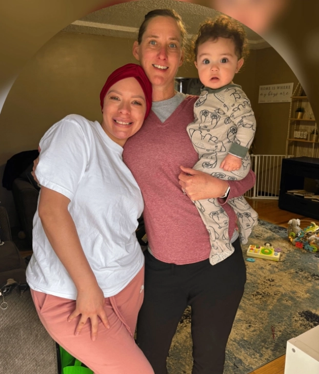 Three generations of family share a warm moment indoors.