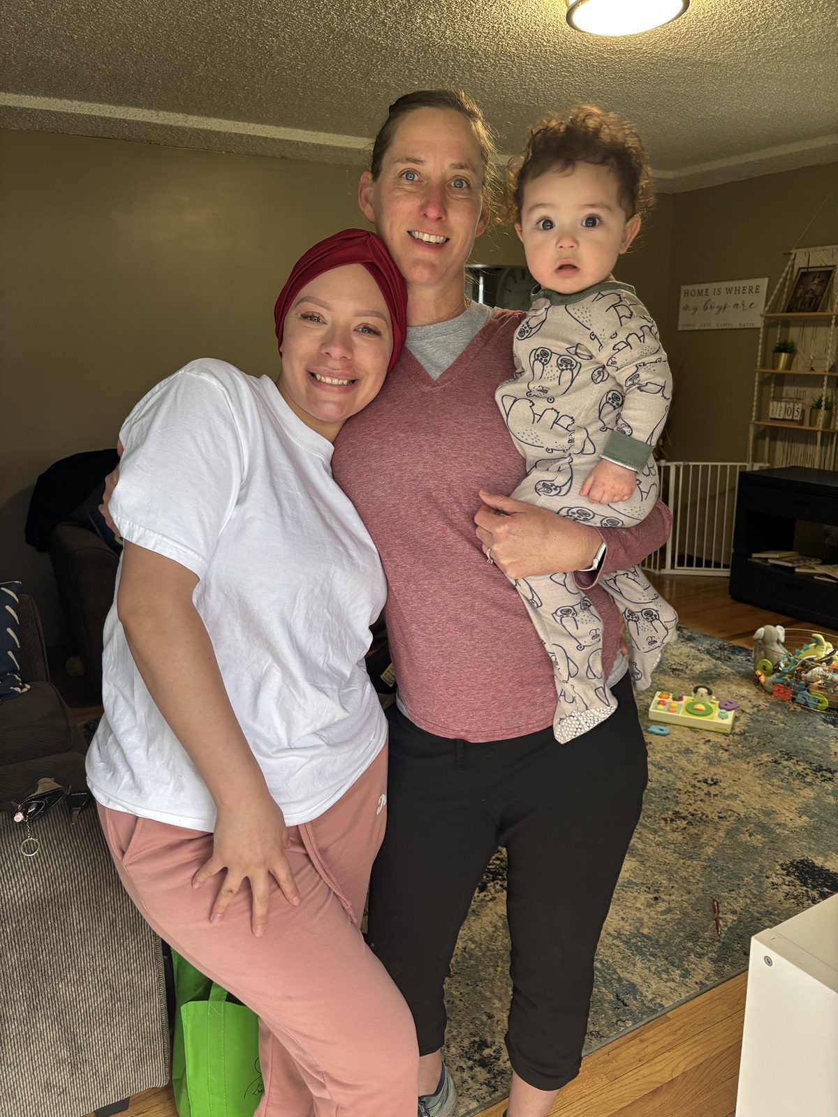A happy family of three posing indoors.